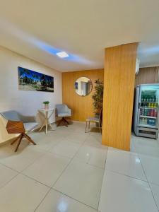a room with a refrigerator and a table and chairs at Hotel Porto Segur0 in Recife