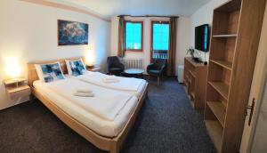 a hotel room with a bed and a tv at Rodinný "Hotel U Můstků" in Desná