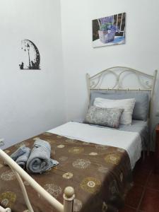 a bedroom with a bed with a blanket and pillows at El Refugio in Aracena