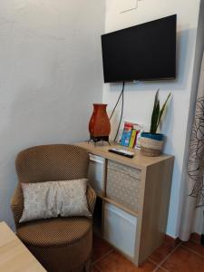 a desk with a chair and a television on a wall at El Refugio in Aracena