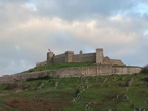 a castle on top of a grassy hill at El Refugio in Aracena