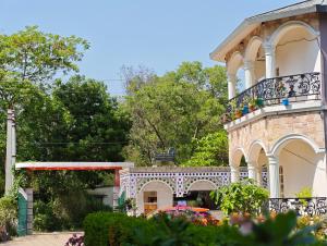 a building with a balcony with flowers on it at Dip Holidays Resort in Shānti Niketan