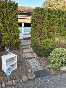 a garden with a small table and a hedge at Nur ein paar Schritte zum Dümmersee in Hüde