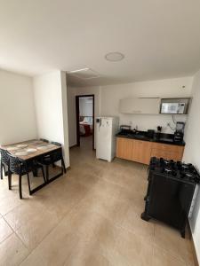 a living room with a table and a kitchen at Casa da Dinda 202 in Rio das Ostras