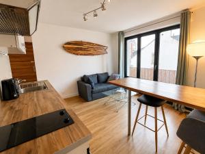 a kitchen and living room with a table and a couch at Éclat d'Écume - Vue mer - Hypercentre - 31 M2 - Quiberon in Quiberon