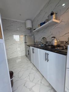 eine Küche mit weißen Schränken und Marmorwänden in der Unterkunft Ammour Apartment in Chefchaouen