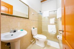 a bathroom with a white toilet and a sink at Hotel Optimum in Pereira +33 photos