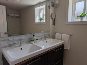 a bathroom with a white sink and a mirror at Modern, private & luxurious executive suite in Delta