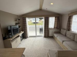 a living room with a couch and a tv at Modern Seton Sands Caravan - sleeps 6 in Port Seton