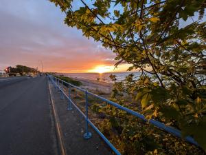 an empty road with a sunset in the background at Coastal Caravan at Seton Sands -Near Edinburgh in Port Seton