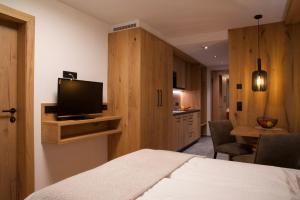 a bedroom with a bed and a tv and a kitchen at Versalerhof in Ischgl