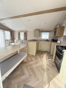 a large kitchen with wooden floors and a counter top at Modern Seton Sands Caravan - sleeps 6 in Port Seton