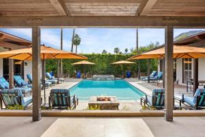 a swimming pool with chairs and umbrellas at Desert Solstice in Palm Springs