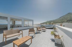 a patio with benches and tables on a roof at Ponente & Maestro Rooms in Favignana
