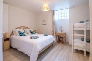a bedroom with a white bed with blue pillows at Gîte de l'Esplanade-18 min du Puy du Foù-Ventilateurs- Billard- Baby-foot-Fléchettes-Grande maison de bourg spacieuse de 200m2- Famille-Amis-Groupe in Pouzauges +43 photos