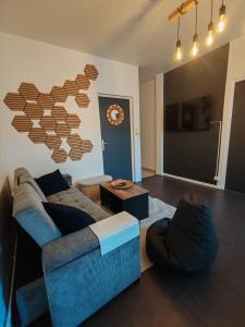ein Wohnzimmer mit Sofa und Tisch in der Unterkunft Le Maley in Dunkerque