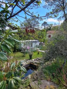 a garden with a pond in front of a house at Chalet de la Source in Casanova