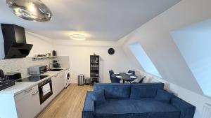 a living room with a blue couch and a kitchen at 247 Reside - Apartment SZ3 in Straubing