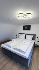 a bedroom with a large bed with white sheets at 247 Reside - Apartment SZ3 in Straubing