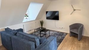 a living room with a blue couch and a chair at 247 Reside - Apartment SZ3 in Straubing