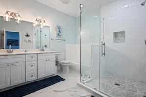 a bathroom with a glass shower and a toilet at Let's get Beachy! in Bolivar Peninsula +40 photos
