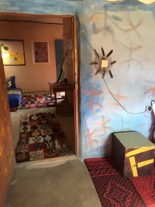 an open door into a room with a room with a rug at Merzouga Hostel in Merzouga