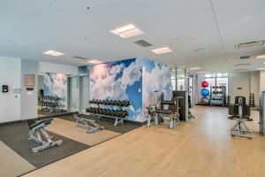 a gym with exercise equipment and a mural of clouds at Walk to MIT & T Stop! Kendall Square Extended Base in Cambridge