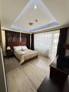 a bedroom with a bed in a room with windows at Hotel Milán in Cuenca