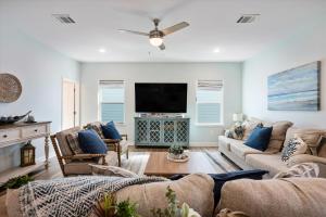 a living room with couches and a flat screen tv at Let's get Beachy! in Bolivar Peninsula