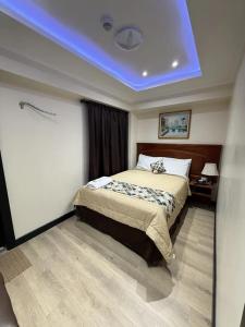 a bedroom with a bed with a blue ceiling at Hotel Milán in Cuenca +2 photos
