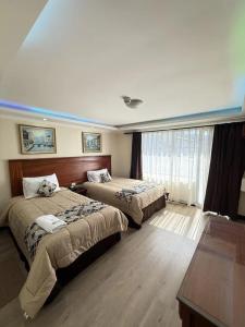 a hotel room with two beds and a window at Hotel Milán in Cuenca
