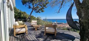 a patio with chairs and a table and a view of the ocean at Villa Azur Horizon in La Turbie