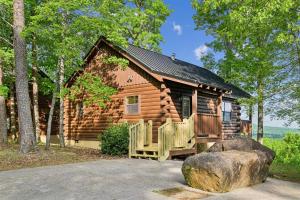a log cabin in the woods with a rock at All About Romance by Venture Smoky Mountains in Henderson Springs