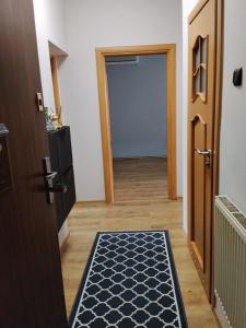 a hallway with a door and a rug on the floor at Apartament Ogrodzieniec in Ogrodzieniec