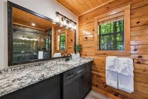 a bathroom with a sink and a large mirror at All About Romance by Venture Smoky Mountains in Henderson Springs +51 photos