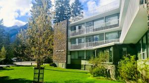 a building with a green lawn in front of it at Bow View Lodge in Banff
