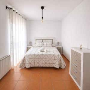 a white bedroom with a bed and a dresser at Mi Rincón Blanco in Grazalema