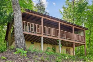 a house in the woods with a tree at A Hen House by Venture Smoky Mountains in Pigeon Forge