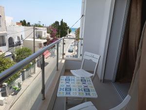 a balcony with a chair and a table and a street at La tulipe d'Hammamet in Hammamet +6 photos