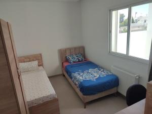 a small bedroom with a bed and a window at La tulipe d'Hammamet in Hammamet