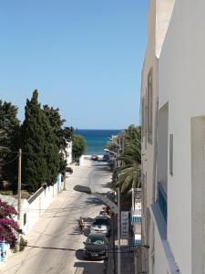 a view of a street with cars and the ocean at La tulipe d'Hammamet in Hammamet