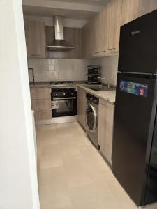 a kitchen with a black refrigerator and a dishwasher at La tulipe d'Hammamet in Hammamet