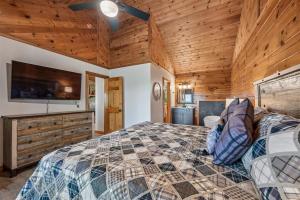 a bedroom with a bed and a flat screen tv at A Hen House by Venture Smoky Mountains in Pigeon Forge
