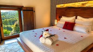 a bedroom with a bed with flowers and a window at Casa Favo de Mel - Jacuzzi & Piscina - Refúgio na Montanha in Arcos de Valdevez