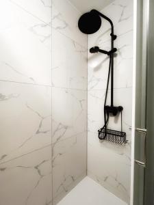 a shower with white marble walls and a black shower head at Apartman Ćosić in Kruševica +7 photos