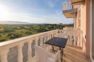 a balcony with a table and chairs and a view at Apartments Peris Resort in Novalja