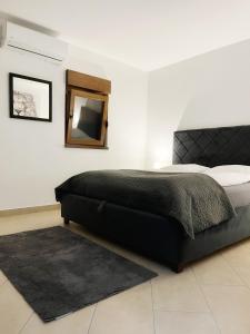 a bedroom with a bed and a mirror and a rug at Apartman Ćosić in Kruševica