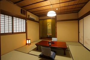 Zimmer mit einem Tisch, Stühlen und einer Lampe in der Unterkunft Tagoto in Aizu-Wakamatsu