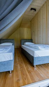 two beds in a room with wooden floors at Leśne Szepty Resort in Zebrzydów +41 photos