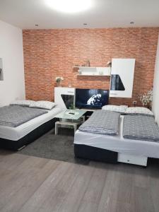 a bedroom with two beds and a brick wall at Apartment Centar in Slavonski Brod